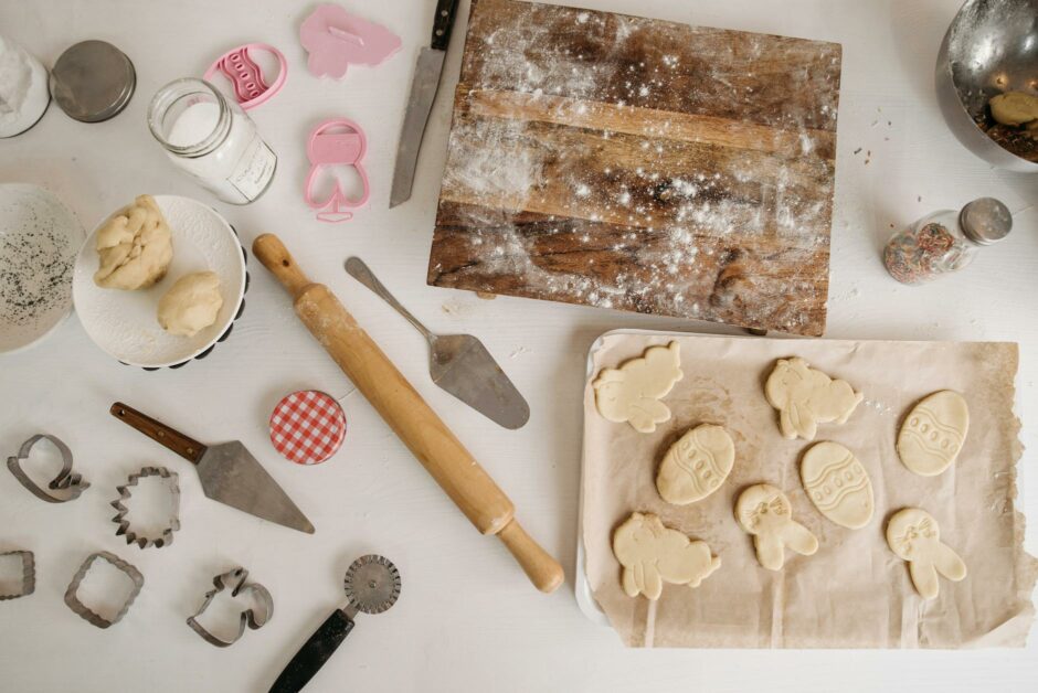 baking utensils on table with shaped dough on tray